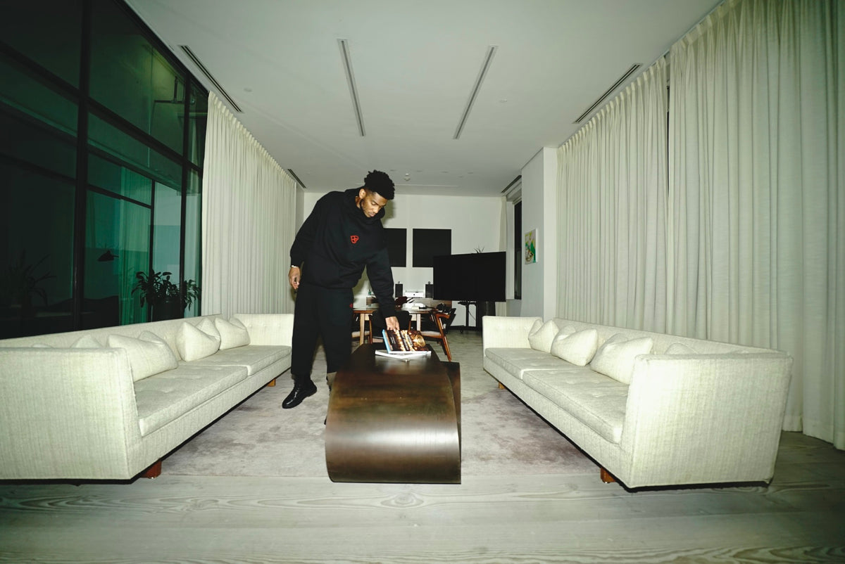 LX3 black hoodie campaign in a room with white sofas