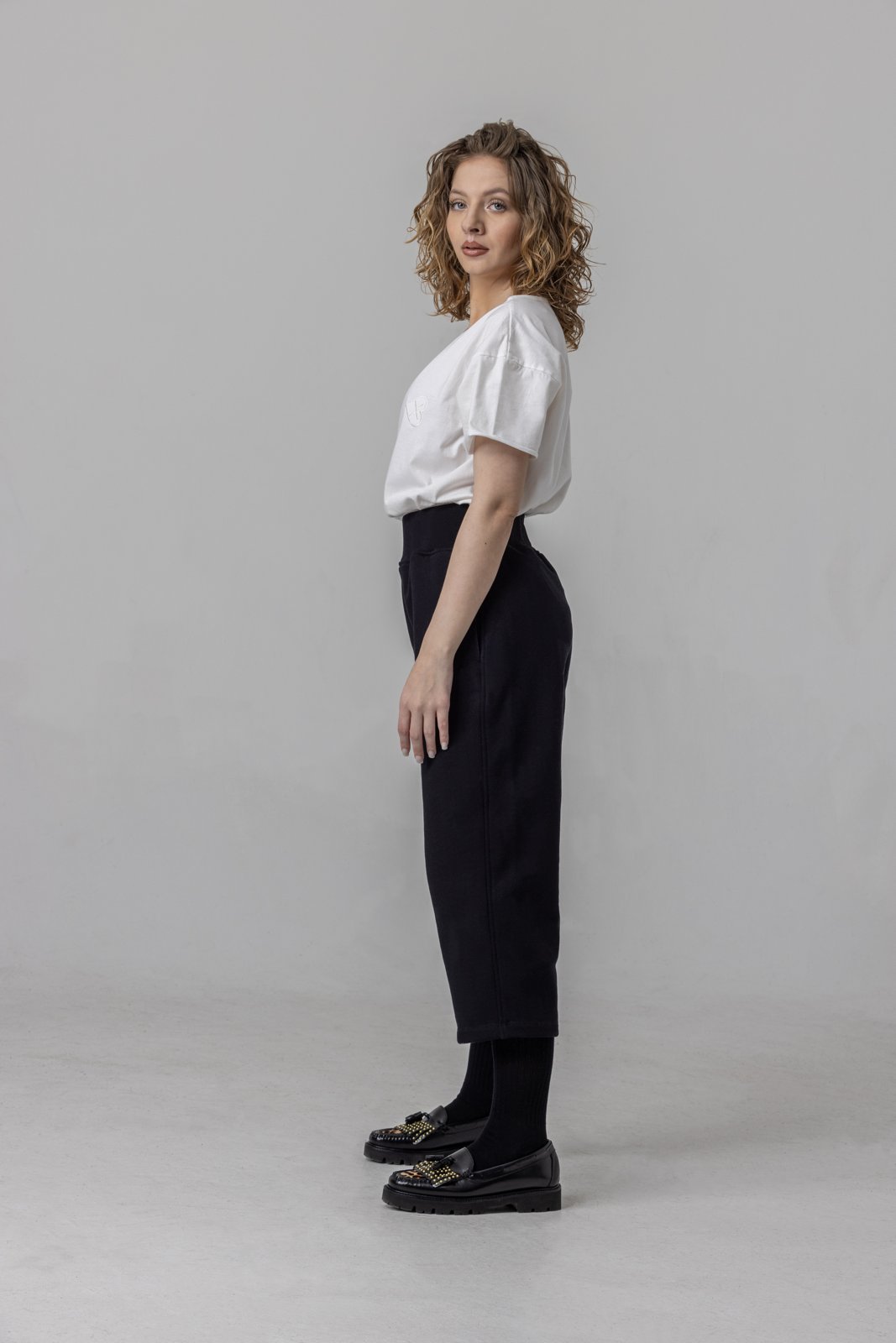 Black cropped sweatpants — side view on model