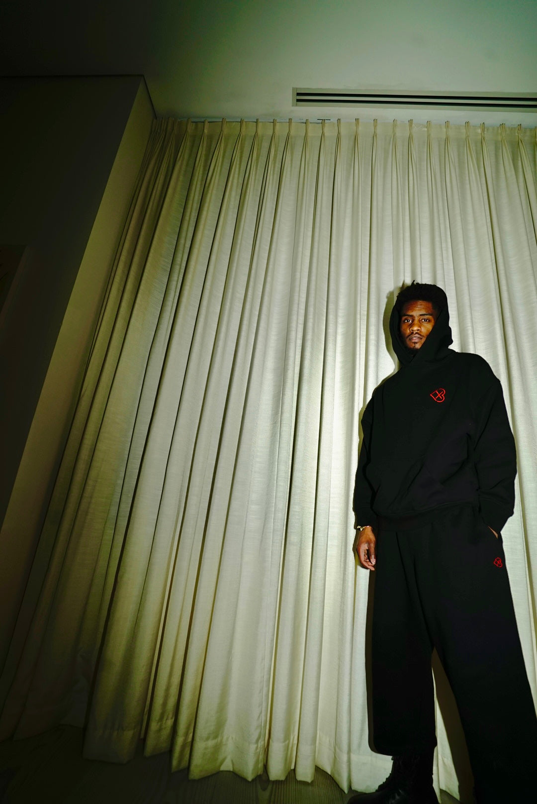 Black LX3 hoodie photographed from the front against pale curtains