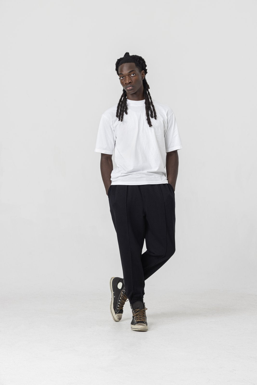 Black pleated sweatpants — front fit and gathered cuffs on model